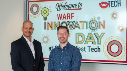 Randolph Ashton and Gavin Knight in front of sign for Summerfest Tech Innovation Day