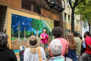 Madison Mayor Satya Rhodes Conway speaking to a crowd in front of the Carbon Cycle mural