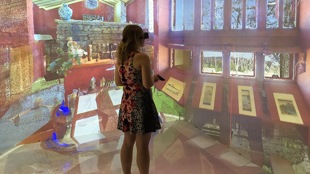 A woman in VR glasses explores a virtual rendering of Frank Lloyd Wright's Taliesin in a Virtual Environment CAVE