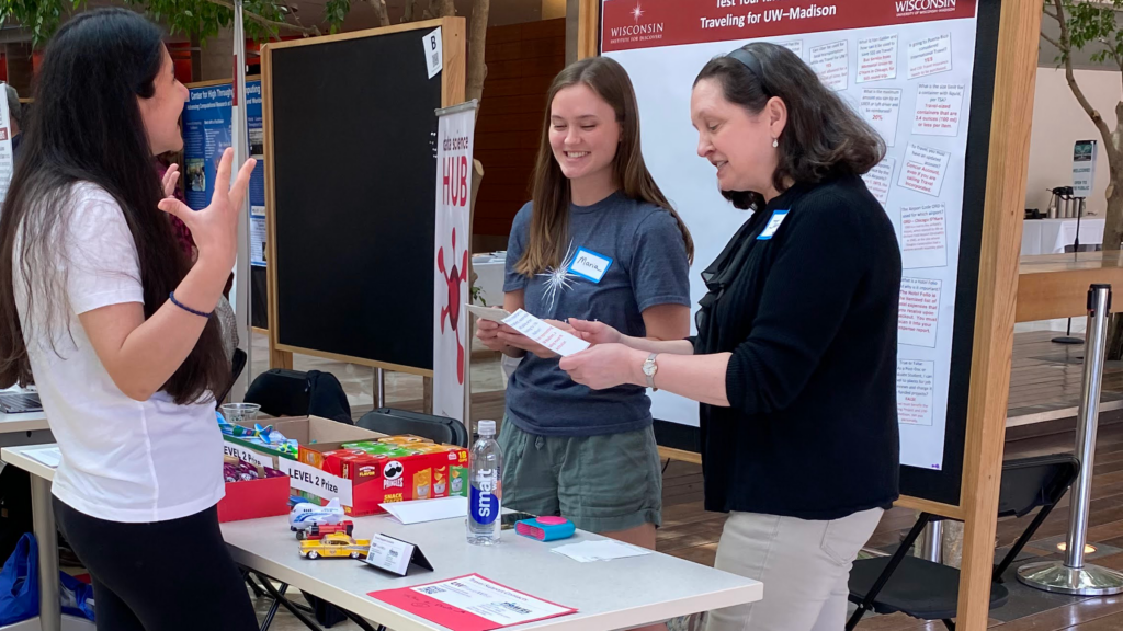 Maria Schultz and Janine Harrison educate a graduate student about proper travel protocols at the Cultivating Connections expo