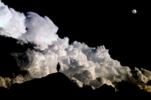 Human in a lab coat on a mountaintop overlooking thunderclouds and the moon
