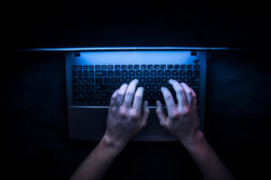 hands on a computer in the dark